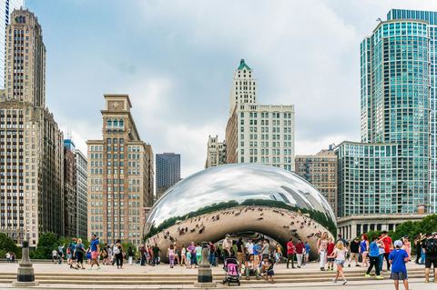 Visitors around Cloud Gate, the mirrored Bean sculpture, in Millennium Park with downtown towers behind