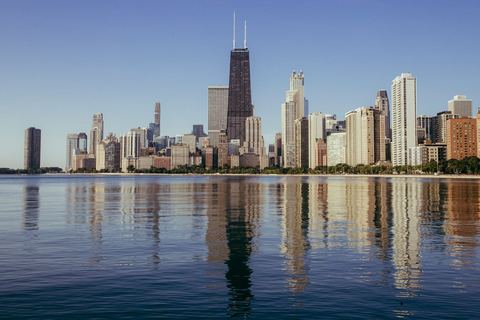 Chicago's skyline reflected in a calm Lake Michigan, seen from the North Side lakefront